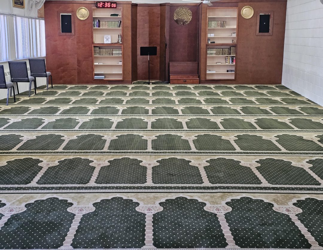 Seminary Prayer Hall - Full view of the musalla with beautiful green prayer carpets and wooden mihrab